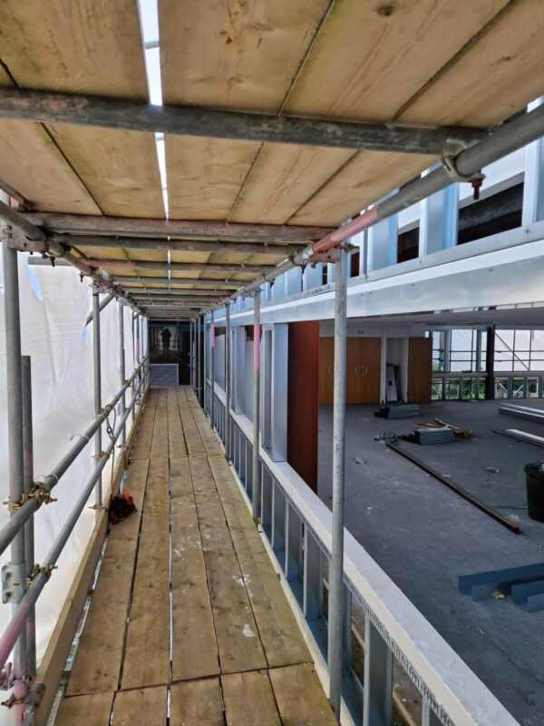 Scaffold walkway along a facade during recladding