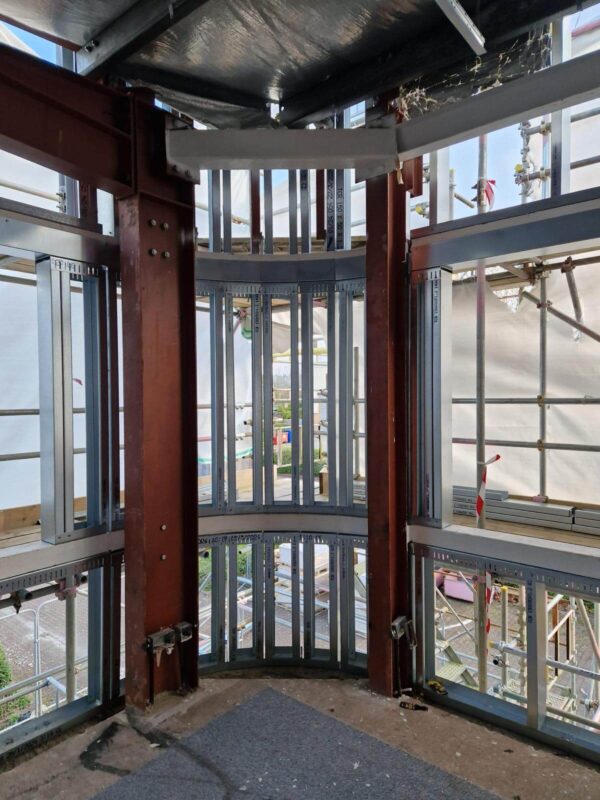 Light-gauge steel framing and rails behind a new rainscreen facade