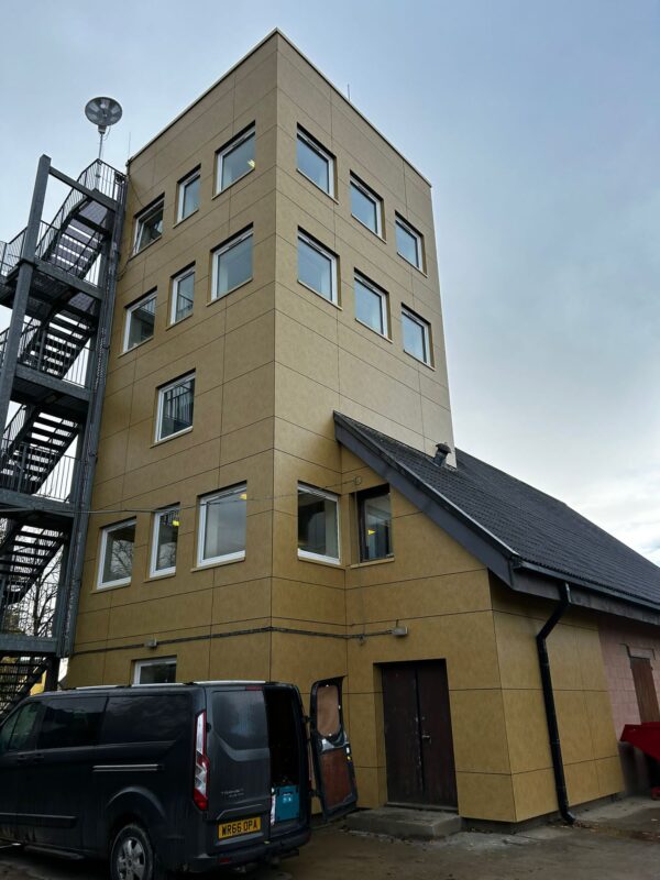 Four-story training building reclad in sandstone-colored rainscreen panels