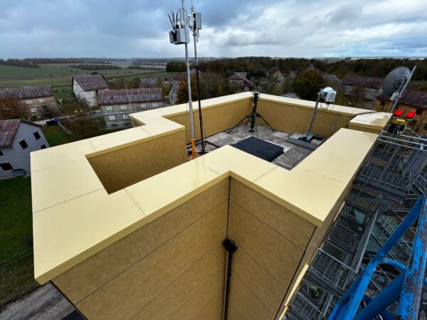 Rainscreen panels wrapped over a roof parapet