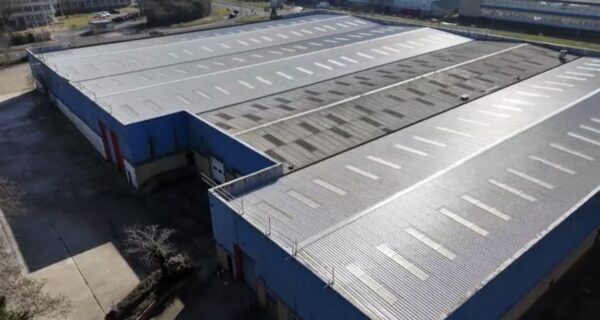 Aerial view of an industrial building roof with rows of skylights