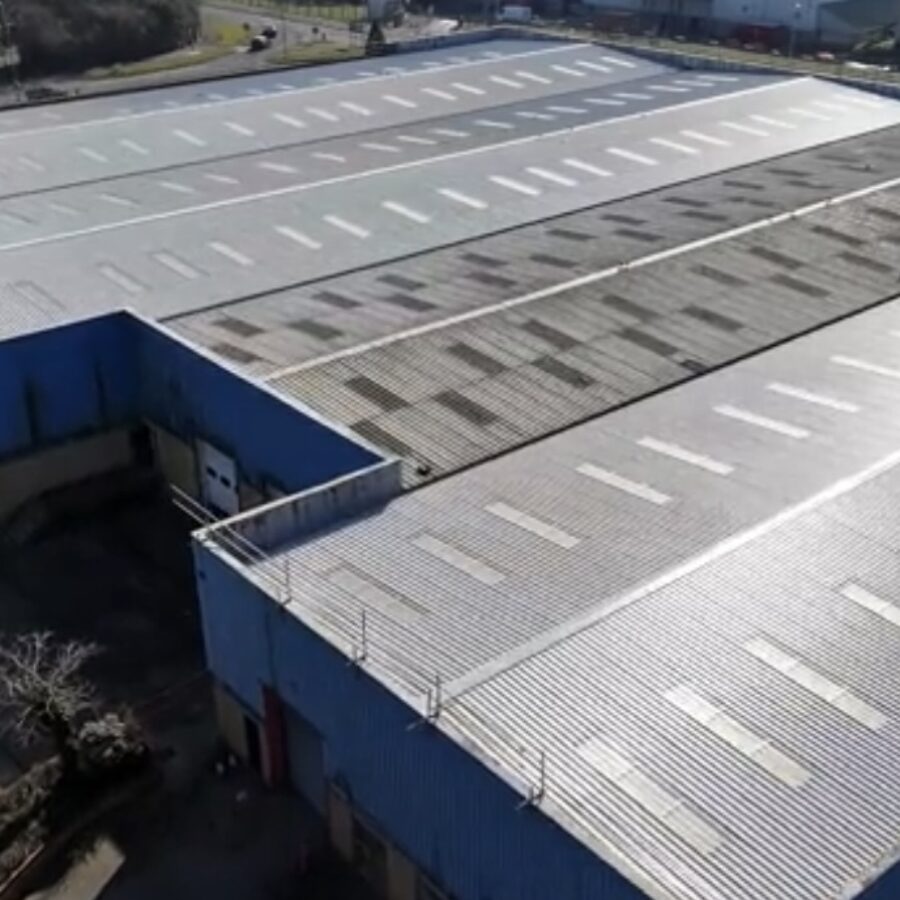 Aerial view of an industrial building roof with rows of skylights