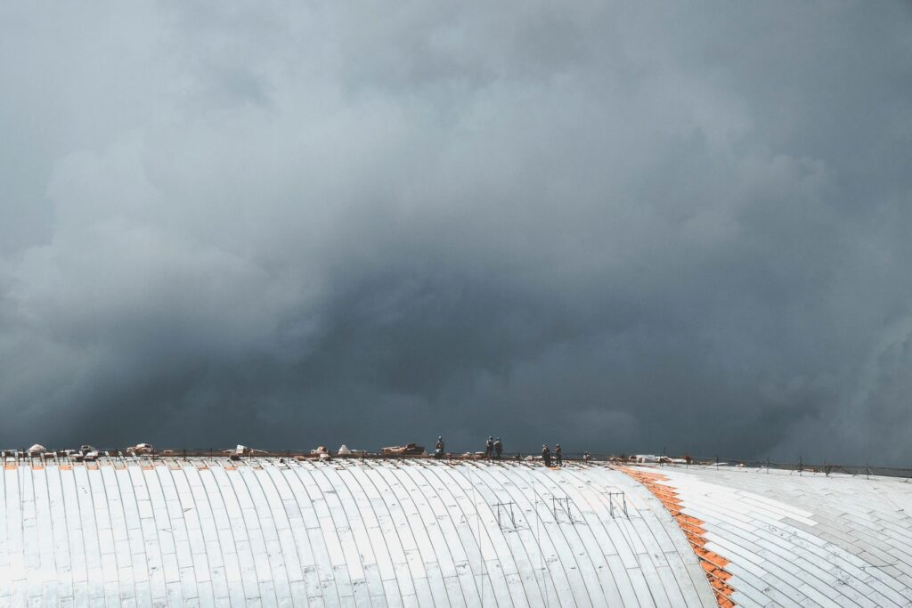 Roofing workers on a large commercial metal roof