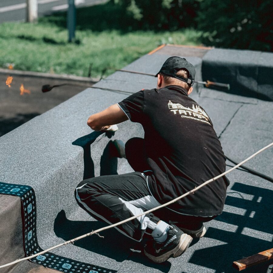 Granulated modified-bitumen roof sheets being installed