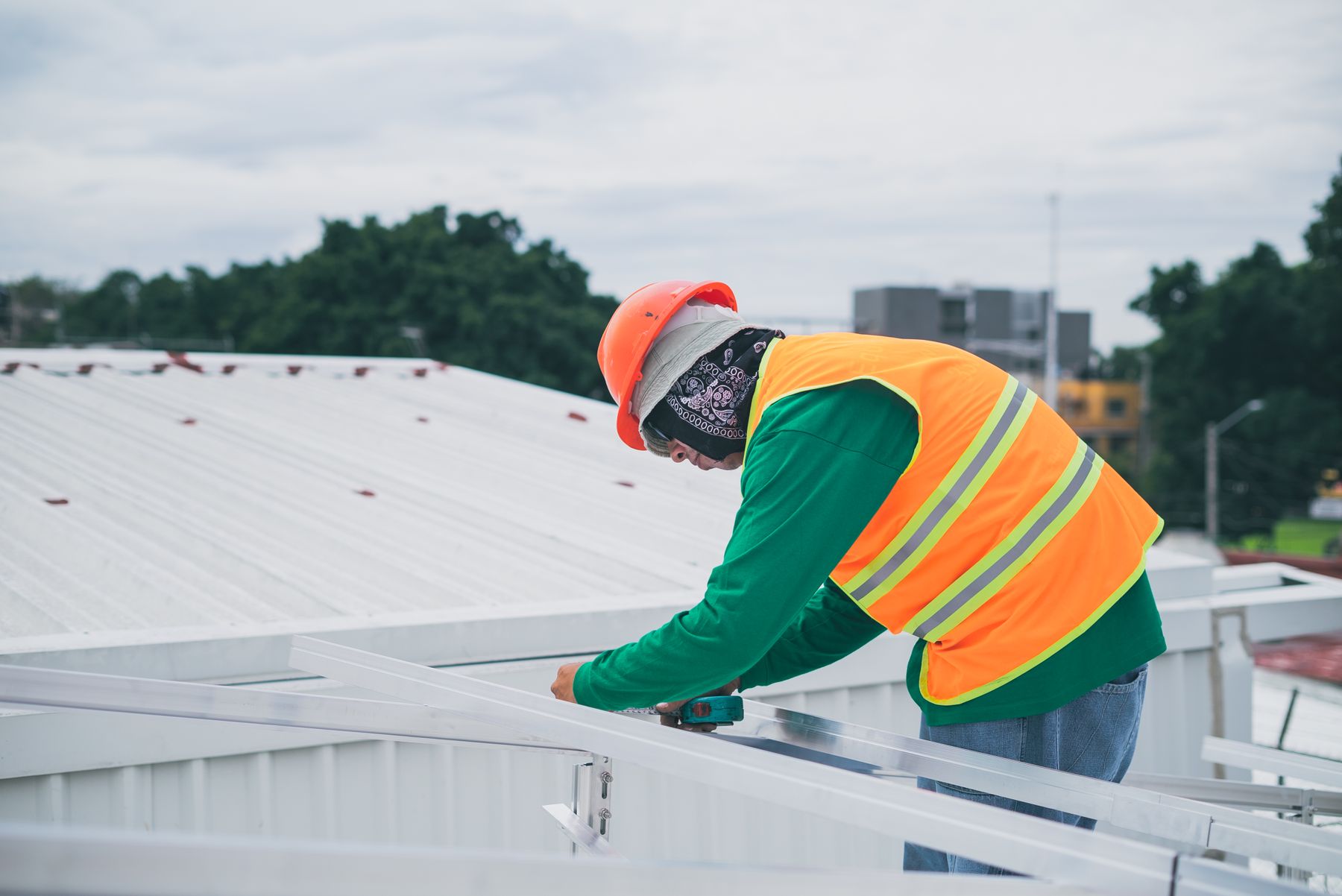 Roofing worker inspecting details on a commercial metal roof