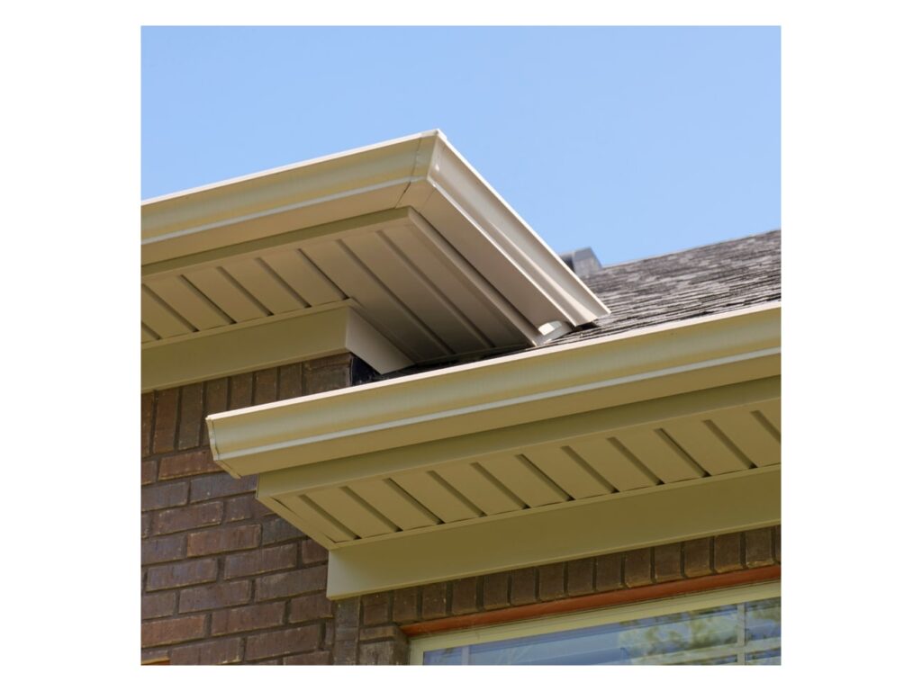 Metal soffit panels installed under roof eaves and gutters on a brick building