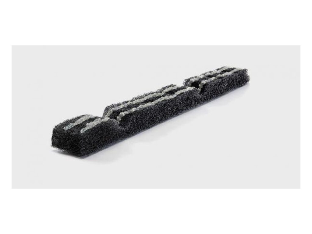 Black profile-cut polyester ridge vent strip with rib-shaped notches on a light background