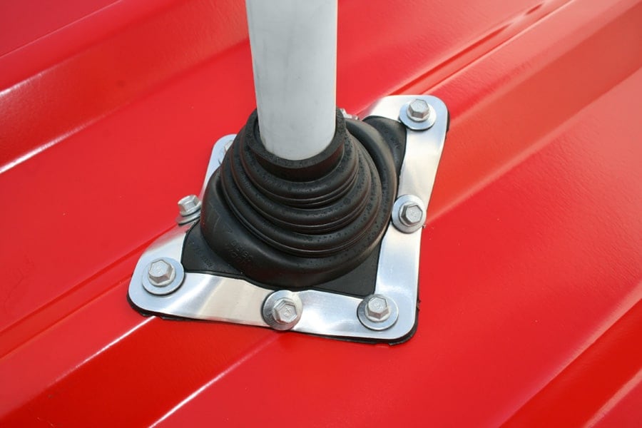 Black Standard Master Flash sealing a pipe on a red metal roof